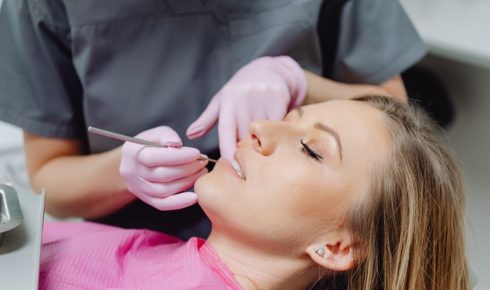 Patientin mit Make-up wird beim Zahnarzt behandelt – zahnärztliche Untersuchung und Wurzelbehandlung